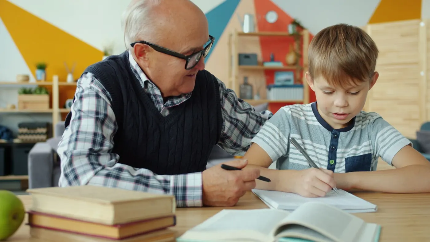 Adulte accompagnant un enfant dans son travail scolaire