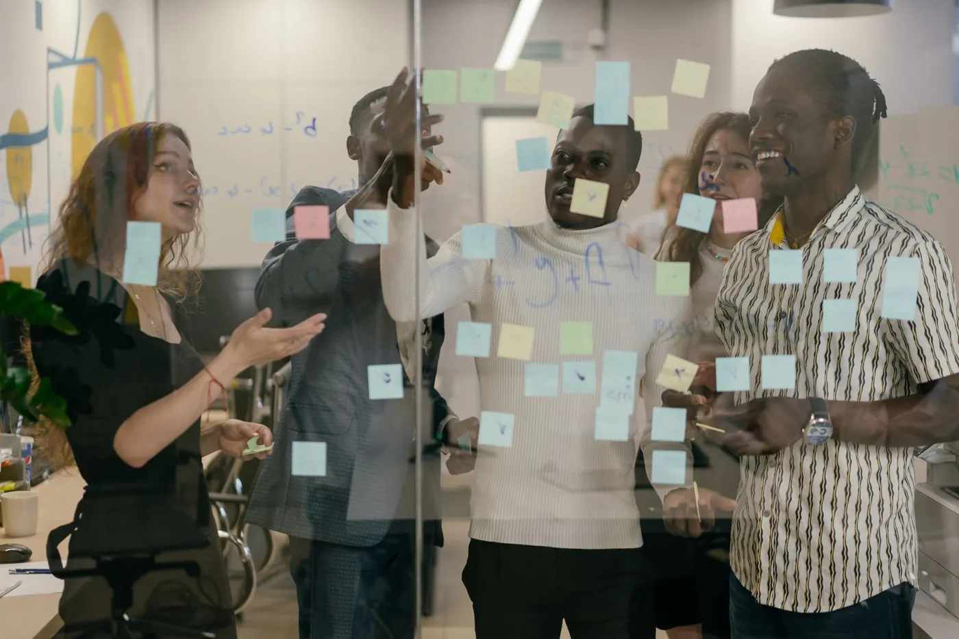 Équipe en atelier collaboratif autour d'un mur de post-it